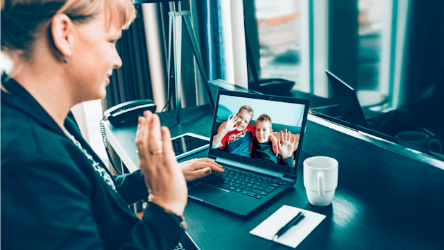 A mom at work facetiming her two kids who is being judged by other working mothers