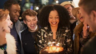 A woman with long curly brown hair smiling while celebrating her 33rd birthday at her party 