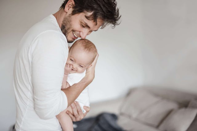 Father holding baby girl at home