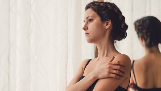 A bisexual woman in a monogamous relationship, with braided hair in a black dress with her back turn...