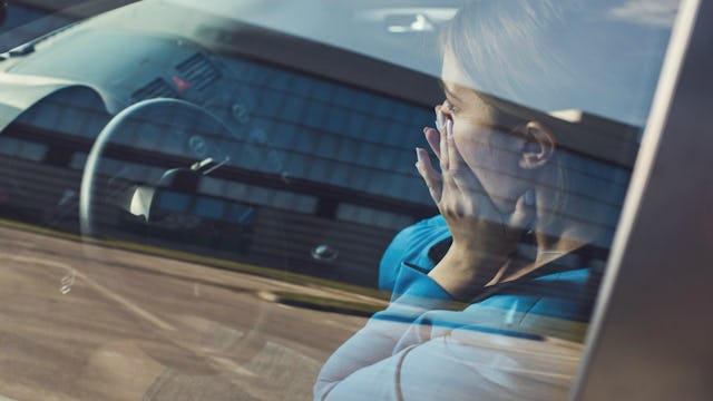 A woman sitting in her car, and covering her face with her hands because she needs to clean her mess...