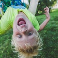 Blond kid with ADHD on a swing upside down 