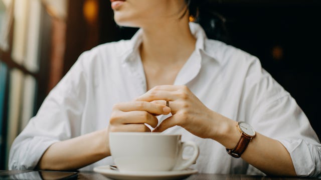 A woman sitting with a coffee cup in front of her