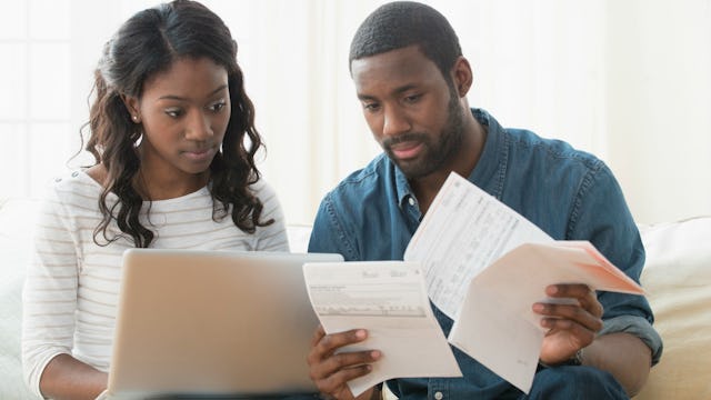 A working couple looking at bills and paying them online
