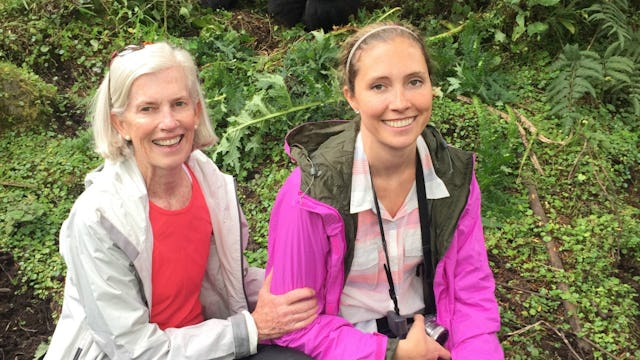Two women who removed their breasts due to BRCA diagnosis smiling toward the camera in the forest