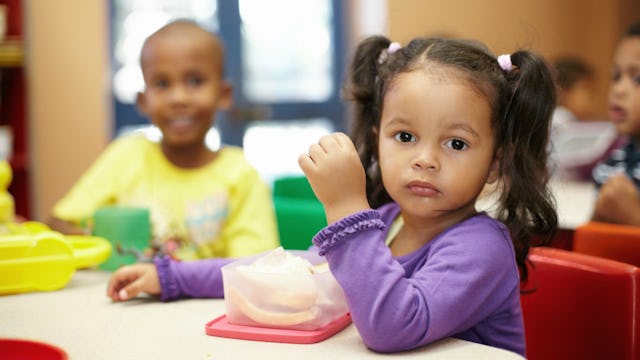 A picky eater small girl eating lunch at school