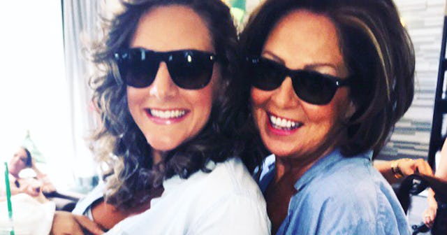 A mother and daughter smiling with sunglasses on.