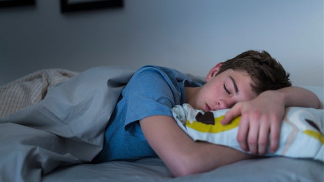A young boy sleeping stomach-down after taking Melatonin 