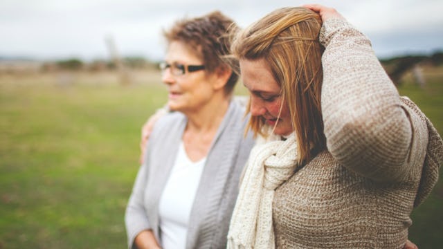 A woman and her mom with harmful behavior taking a walk and hugging in nature 