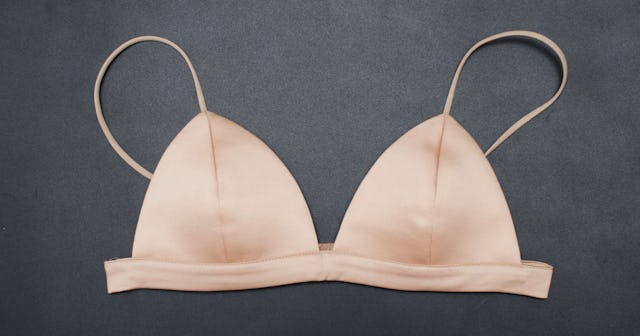 A plain peach silky bra for small-breasted women on a grey background