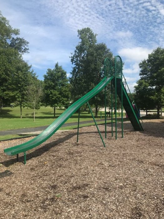 A very long green slide in the park where Kayla K's baby fell from