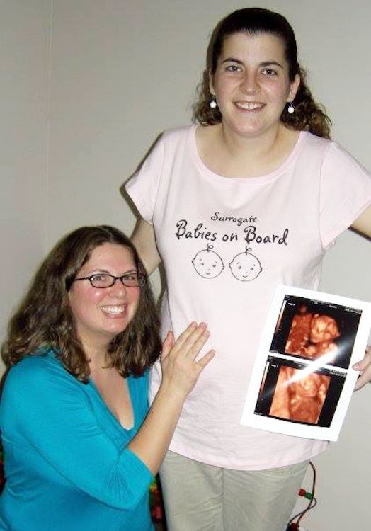 A woman posing with her surrogate, who's holding an ultrasound image