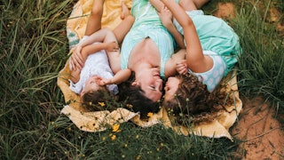 Woman lying on a blanket with her two kids