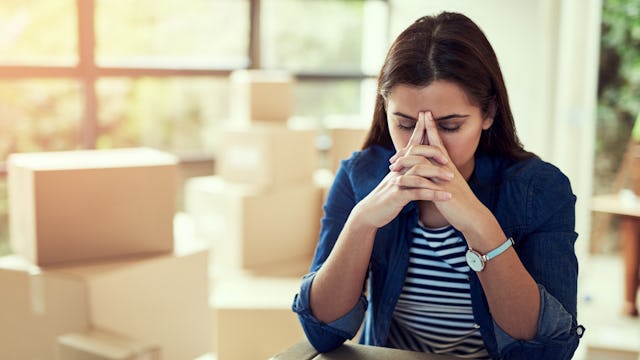 A woman holding her pointer fingers on her forehead in distress on Mother's Day