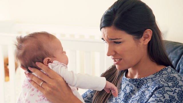 A mom experiencing postpartum anxiety while holding her newborn child 