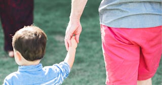 A dad holding his son's hand while walking