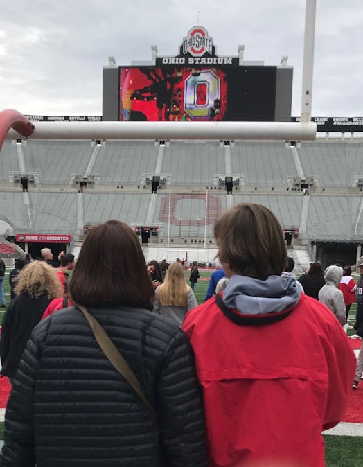Woman wearing a black jacket and her son wearing a red jacket standing in the middle of Ohio stadium