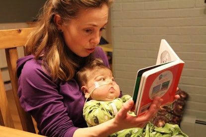 Jennifer Canvasser reading a book and holding her late baby whose life has been taken by NEC