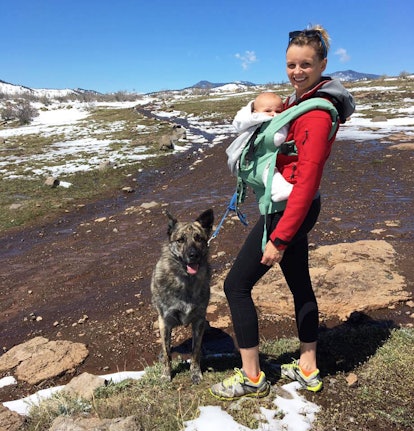 A mom with ppd hiking with her baby in a carrier and her dog by her side