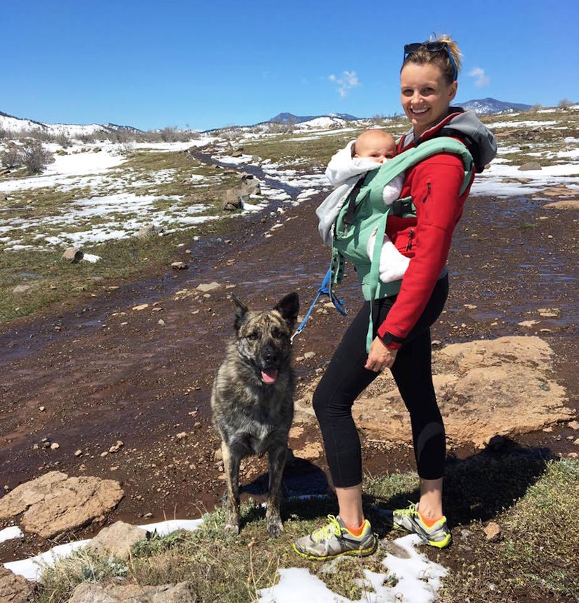 A mom with ppd hiking with her baby in a carrier and her dog by her side