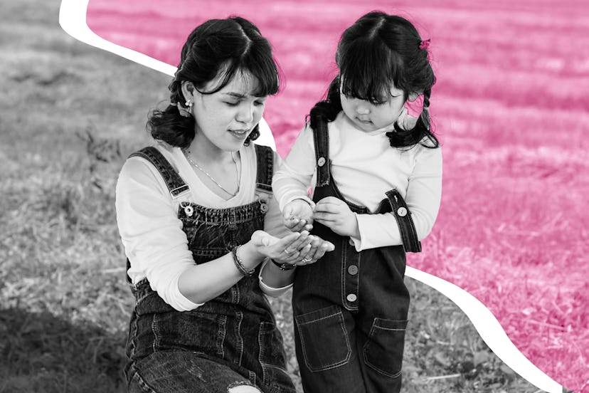 Mother sitting in the grass while daughter stands next to her