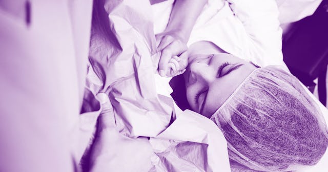 A mother touching her newborn child for the first time in the hospital in black and white with a blu...