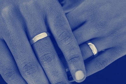 Married couple holding each other's hands with their wedding rings showing 