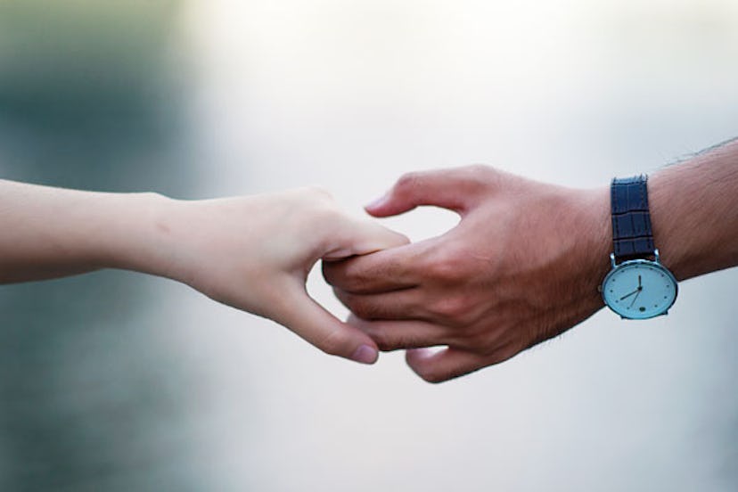 A closeup of two people holding hands 