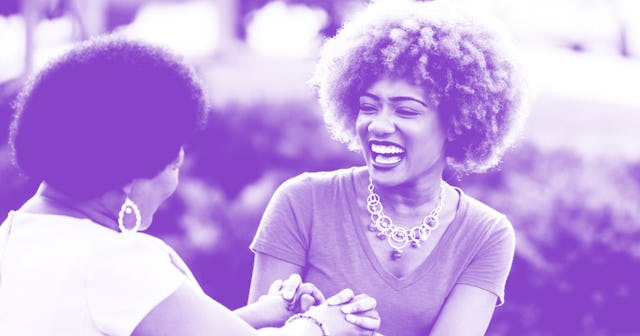 A 40 year old woman holding her mother’s hands and smiling with a purple color filter