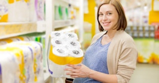 pregnant woman holding toilet paper at a grocery store