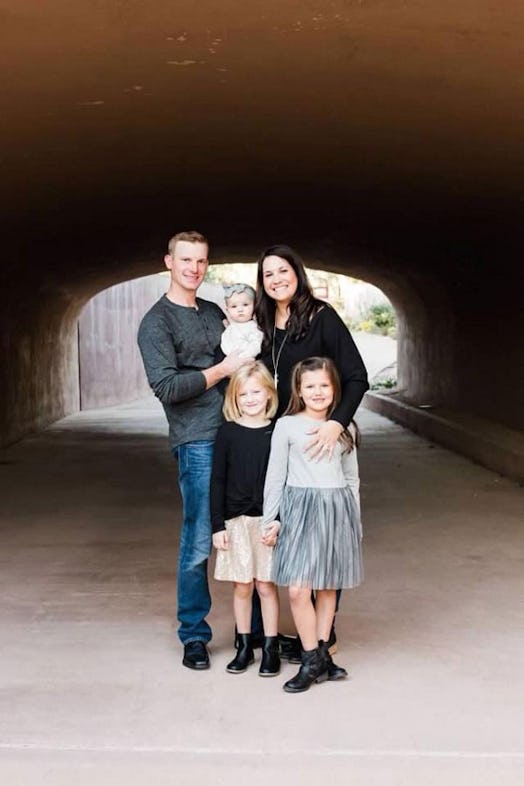 A man and a woman with their three children standing and posing