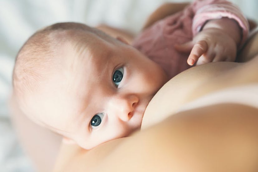 A light-haired, blue-eyed baby breastfeeding from the mother's point of view