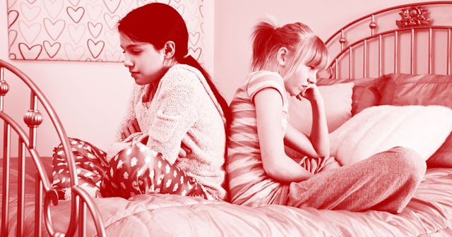 Two girls sitting back to back on a bed with a pink color filter