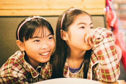 Two sisters sitting at the table 