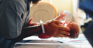 A doctor holding a newborn child