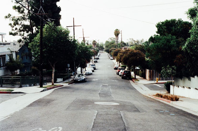 A street with no cars driving, there are just some parked ones