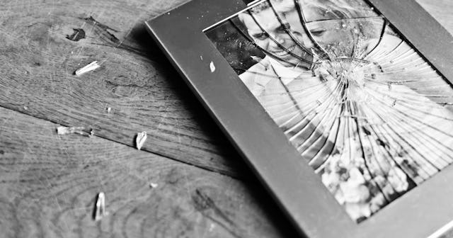 A broken framed picture of a husband who is emotionally and financially unfaithful and his wife in b...