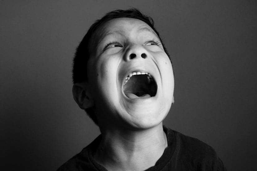 A boy screaming and looking up in black and white