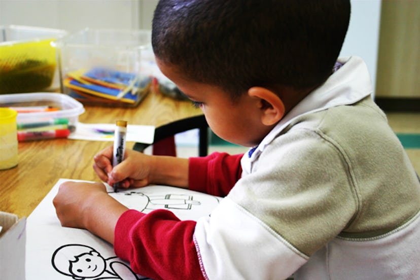 A boy coloring his coloring book 
