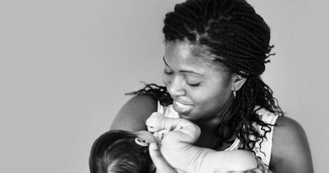 Akosua Taylor holding her baby that had fetal spina bifida surgery and smiling.
