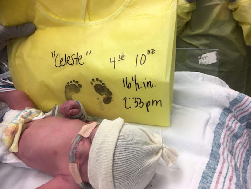 A newborn baby with all information about her birth written on a cloth.