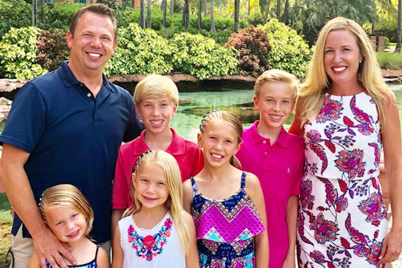 Tara Schoeller posing and smiling with her husband, her three daughters and two sons outside
