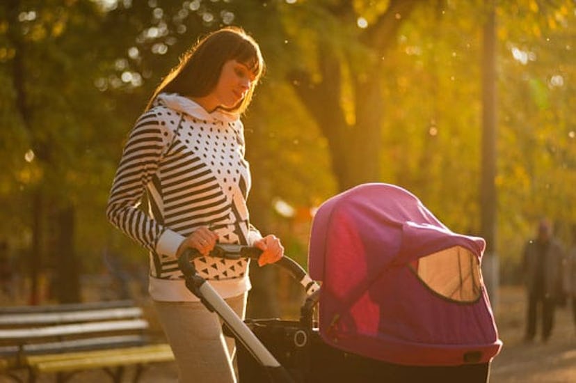 Mother walking with her baby in a stroller