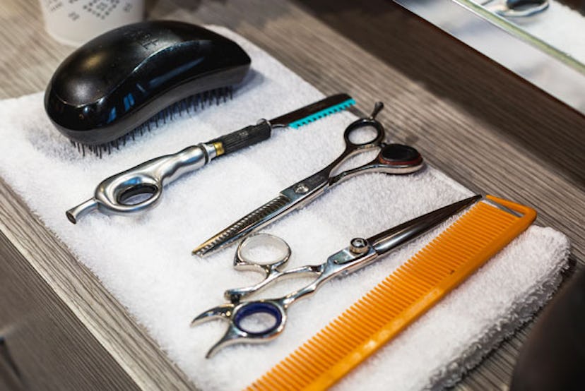 Five tools for cutting children's hair including scissors, a brush and a comb