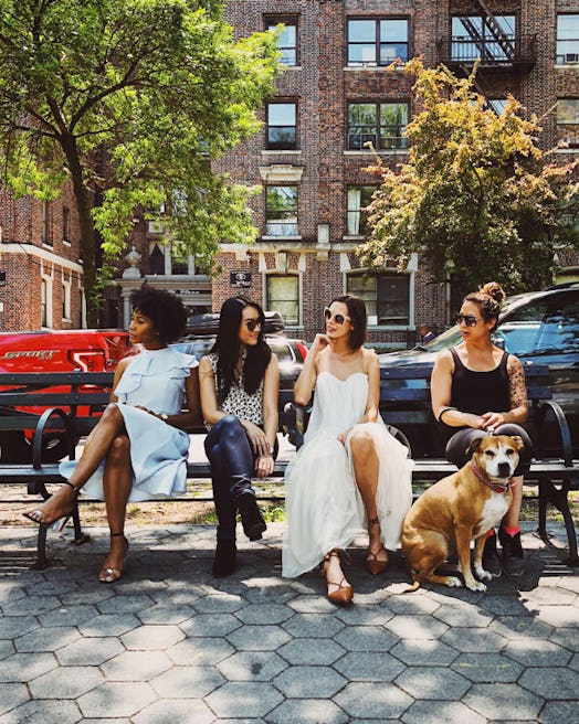 Four young female friends sitting on a bench in New York City