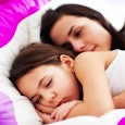 Mother sleeping with her child in bed