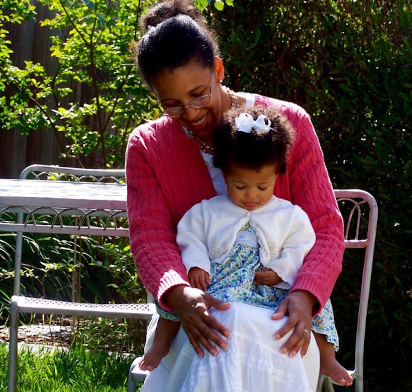 Mother holding her daughter on her lap 