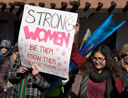 A group of women holding a banner about strong women.