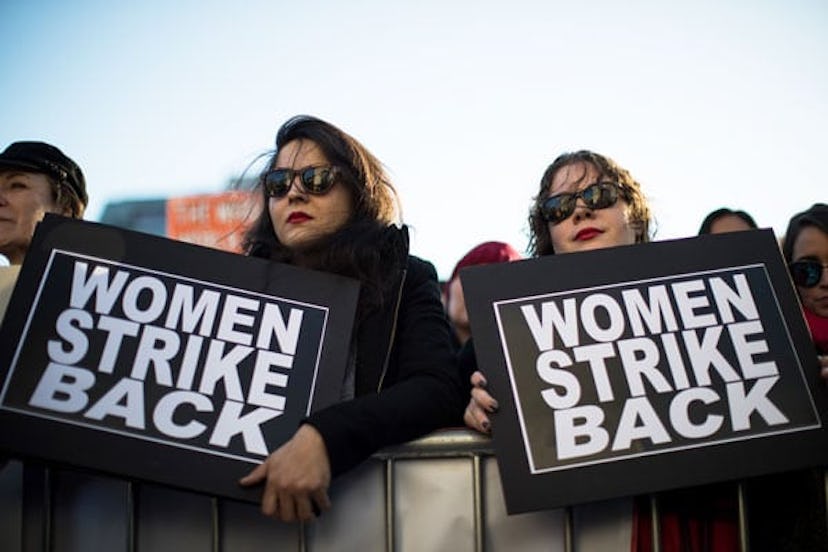 Two women holding banners saying women strike back