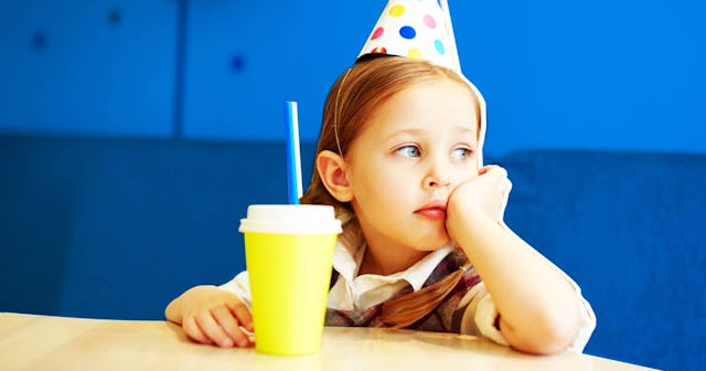 A little girl sitting lonely on a birthday party